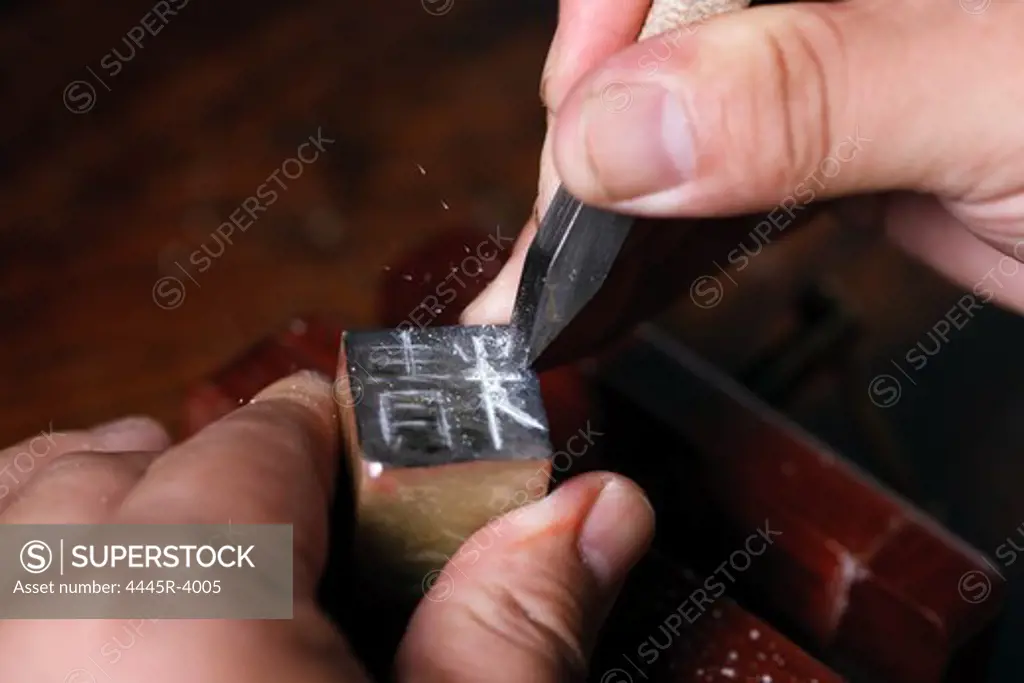 Craftsman carving Chinese character into a Chinese chop