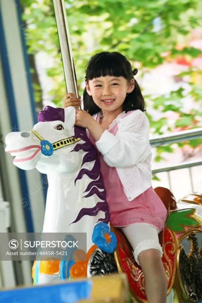 A girl playing merry-go-round outside