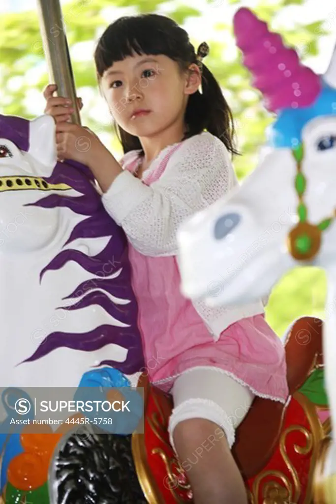 A girl playing merry-go-round outside