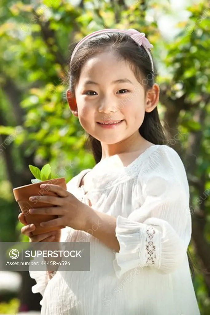 Girl holding potted plant