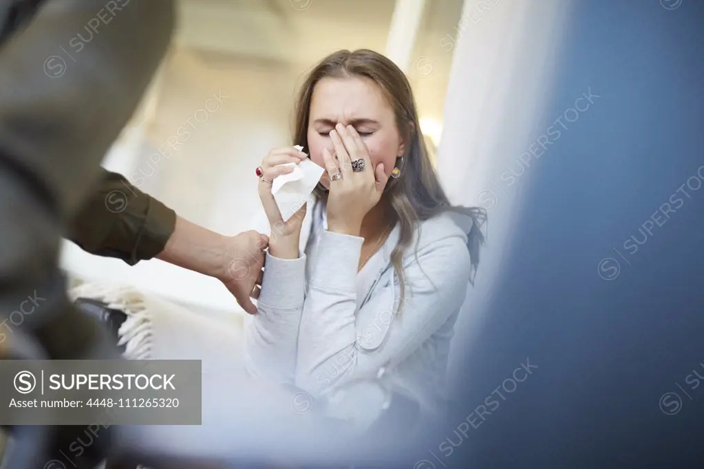 Female doctor consoling sad patient at therapy office