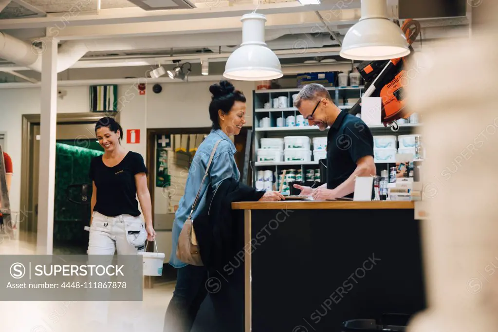 Smiling salesman assisting customer at hardware store