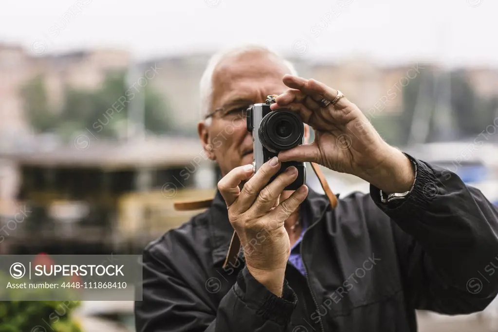 Senior man using camera during photography course