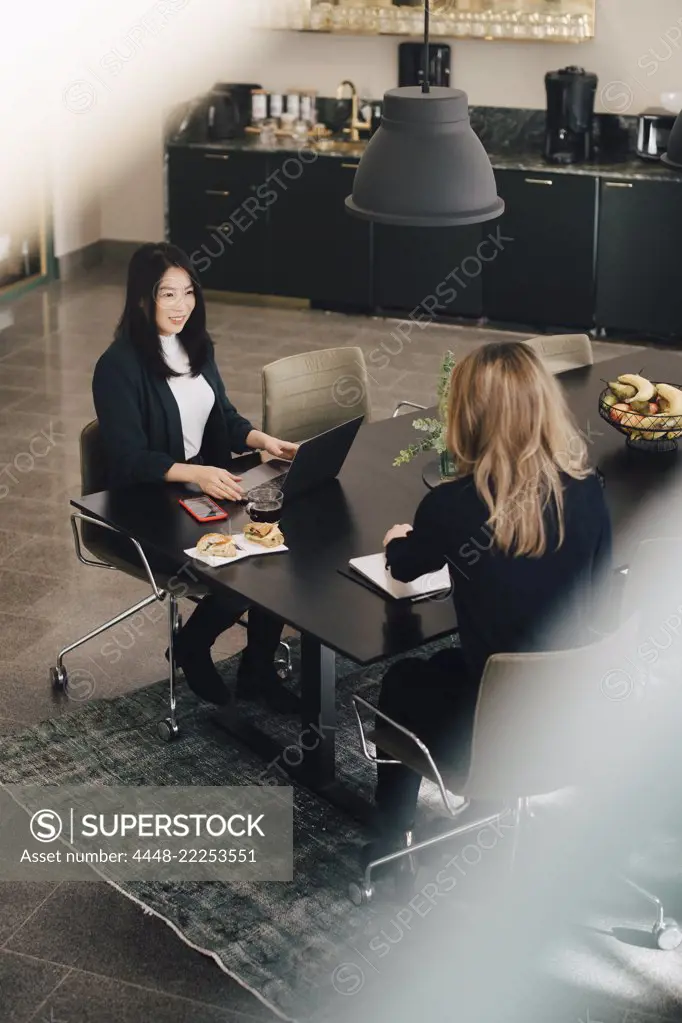 High angle view of female professionals working together at conference table