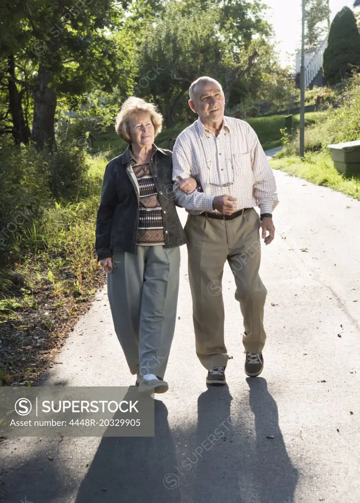 Elderly couple arm in arm
