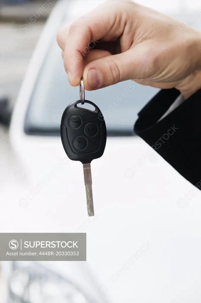 Hand holding car key
