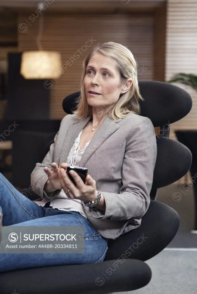 Woman sitting in chair with mobile
