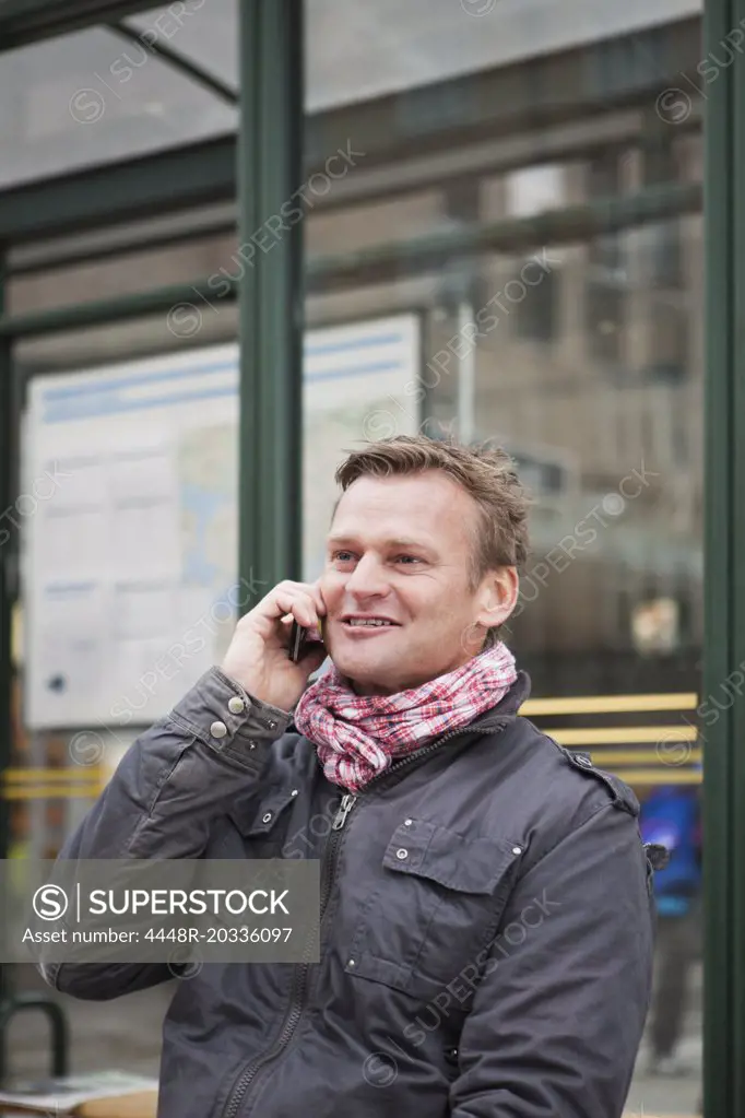 Closeup on man talking and phone and waiting for the bus