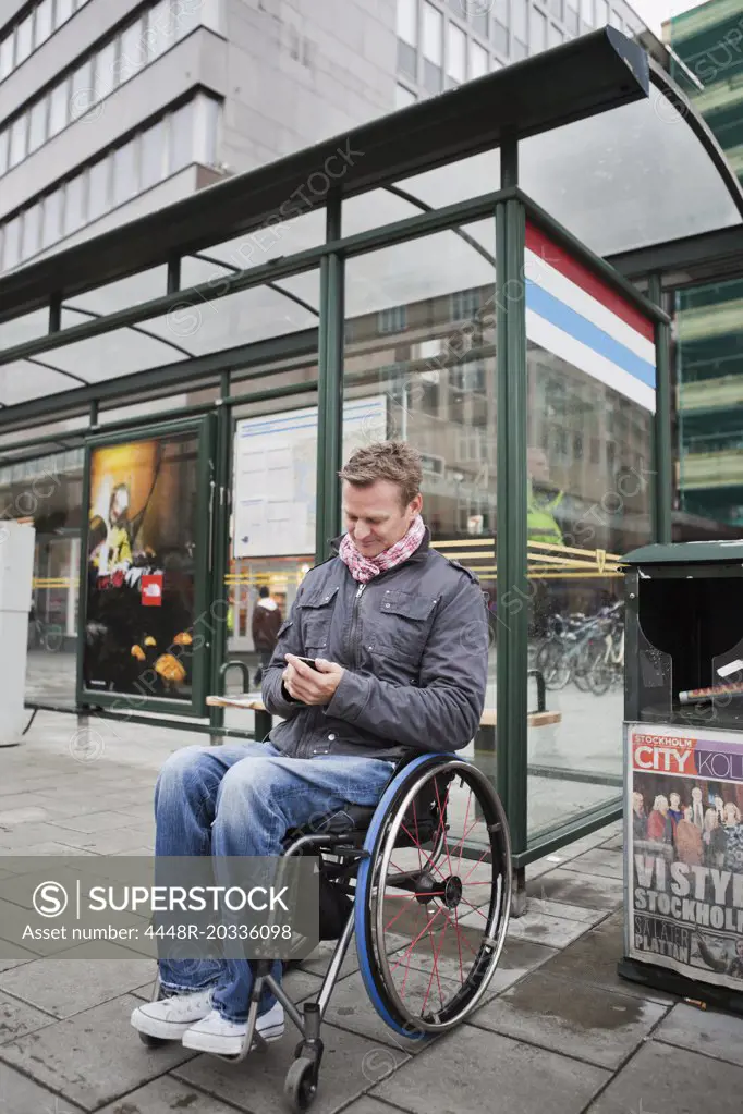 Man in wheelchair waiting for the bus