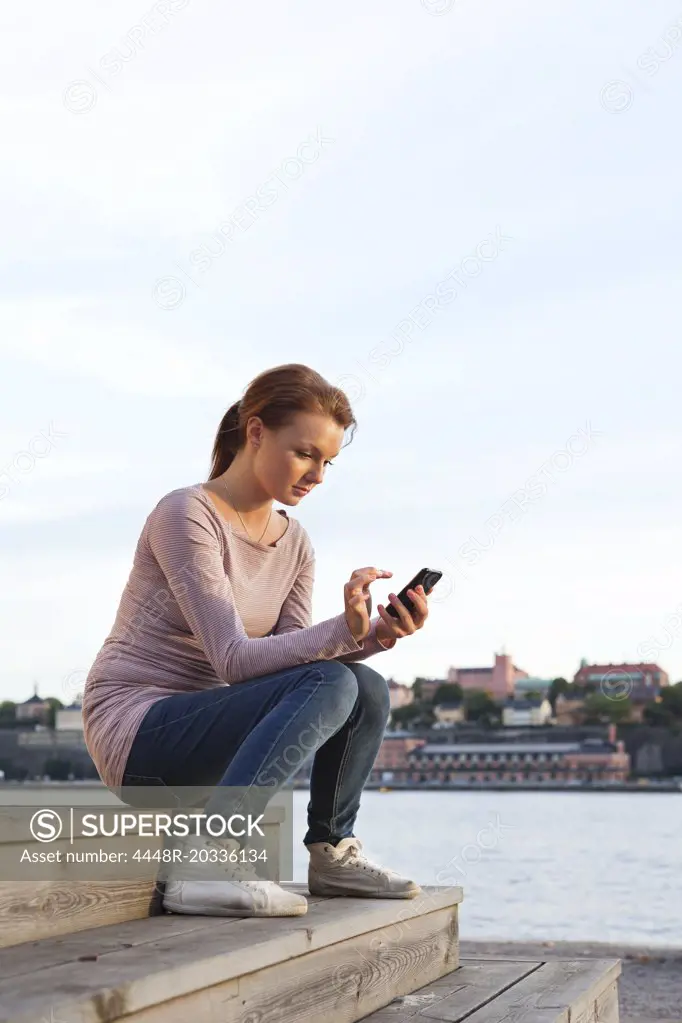 Girl sitting in stairs and looking at cellphone