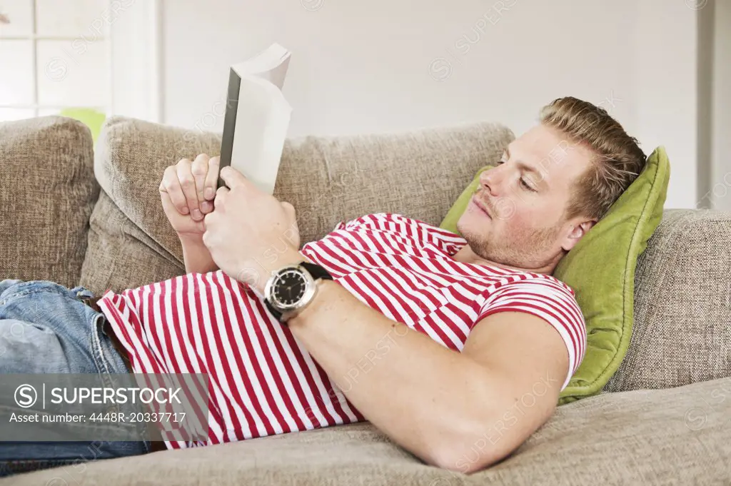 Guy reading book in sofa