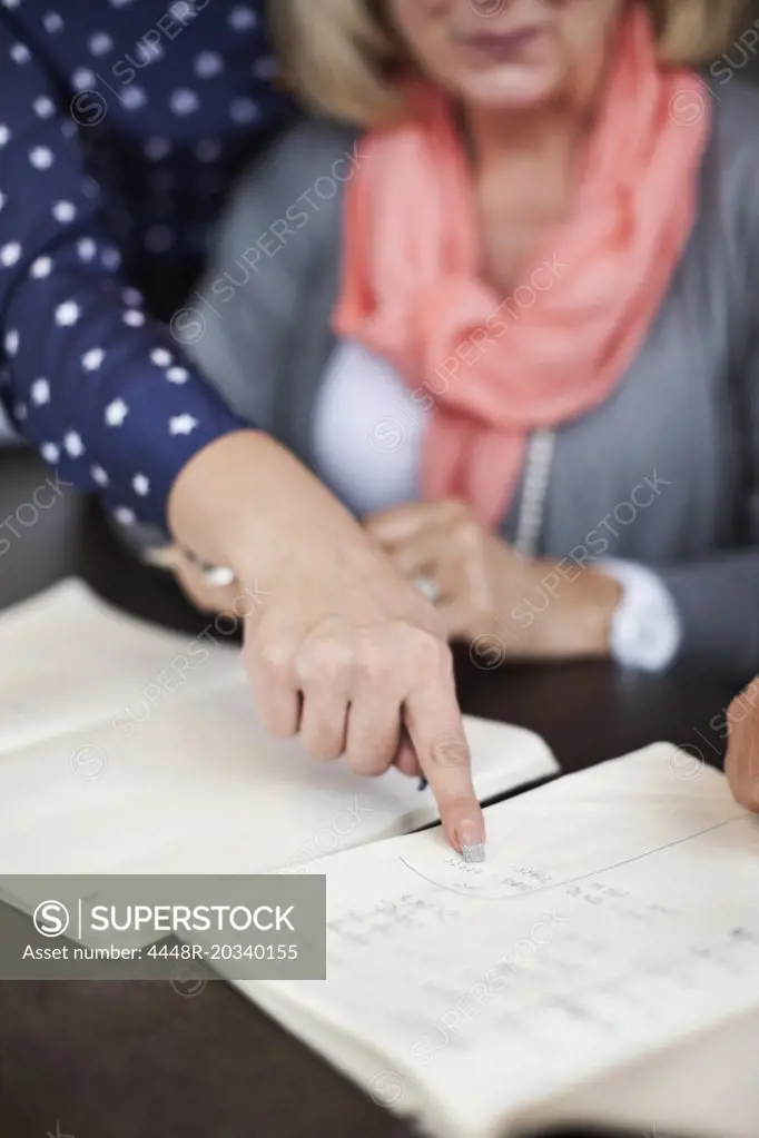 Hand of businesswoman pointing at document