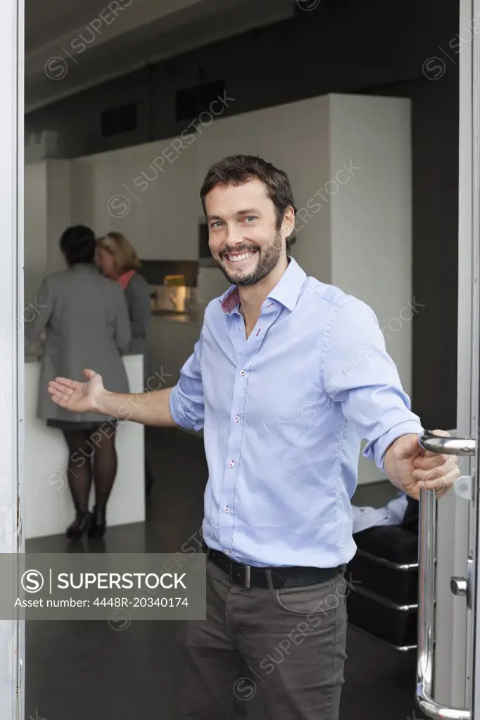 Portrait of a businessman inviting inside