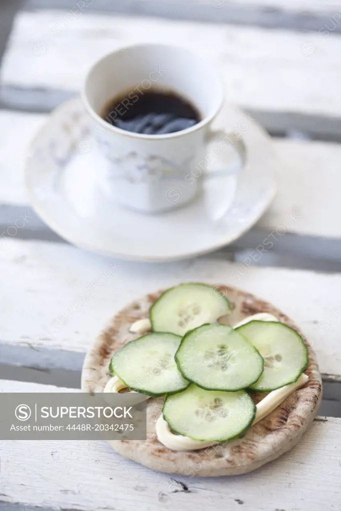 Slices of cucumber on bread with coffee