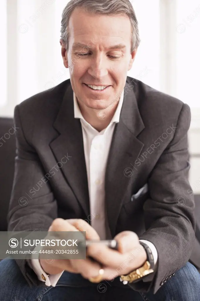 Mature businessman using mobile phone at office