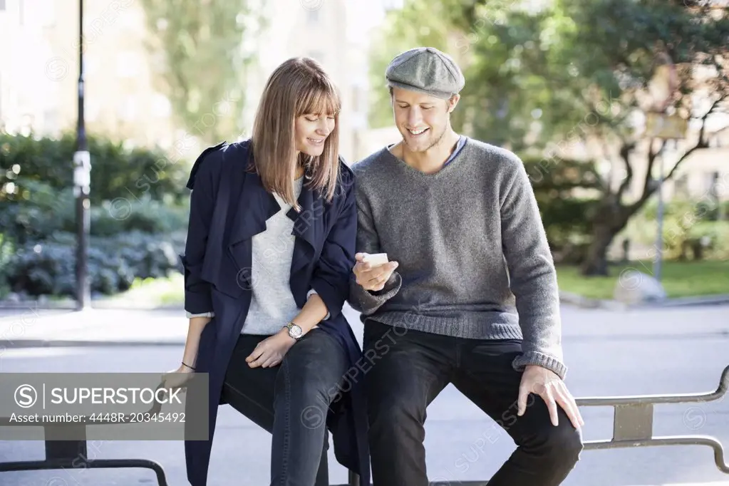 Young couple using mobile phone outdoors
