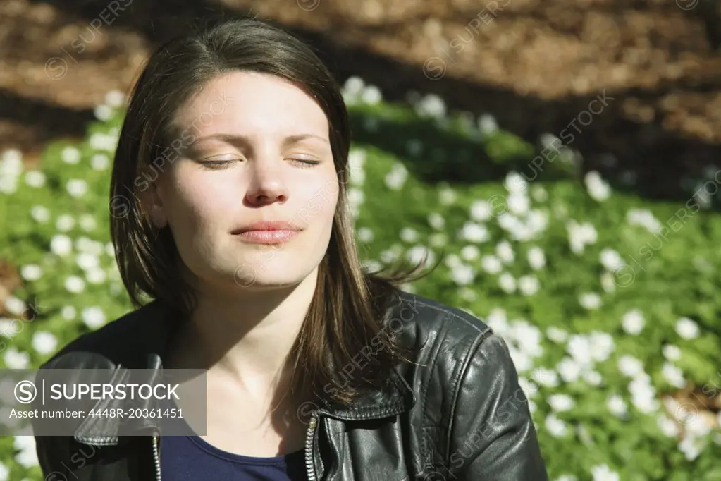 Beautiful woman with eyes closed in sunlight