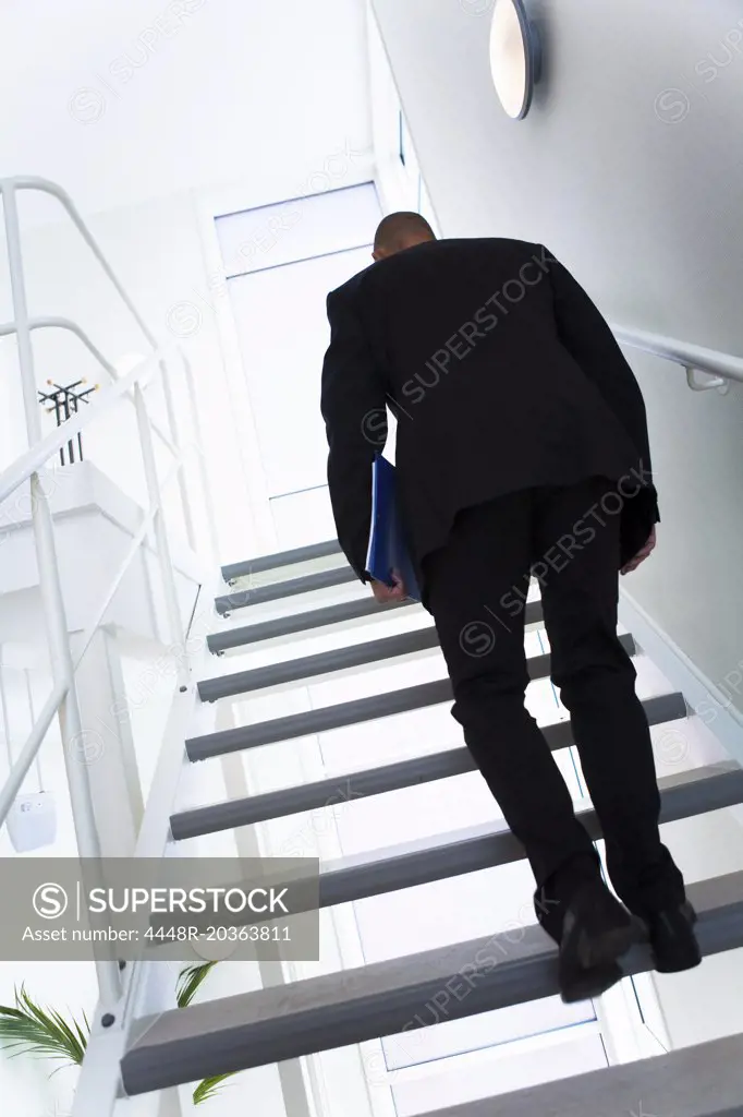 Man in black walking upstairs
