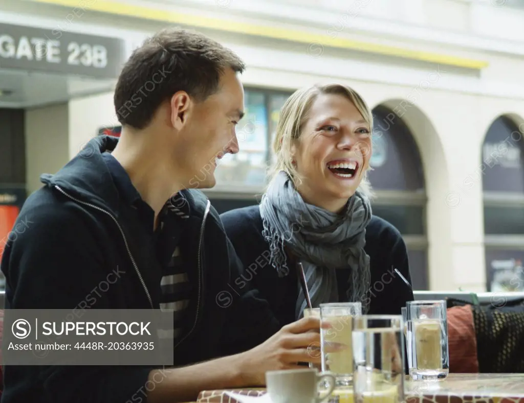 Girl and guy at a café laughing