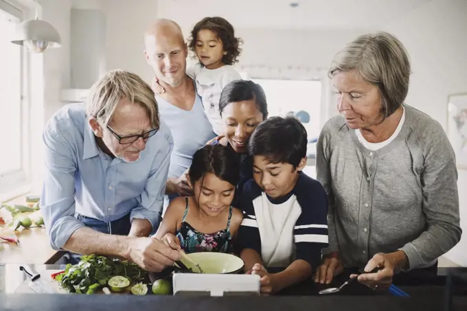 Multi-ethnic family preparing food at kitchen counter