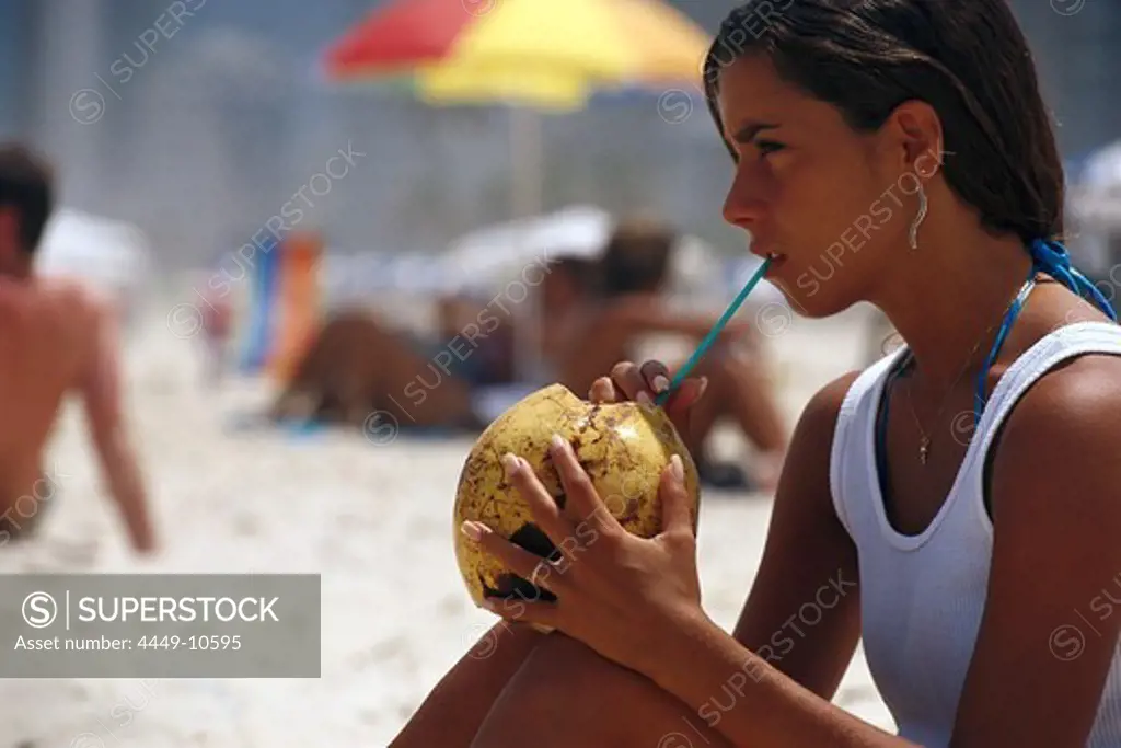 Girl drinking coconut milk on Ipanema Beach, Rio de Janeiro, Brazil, South America, America