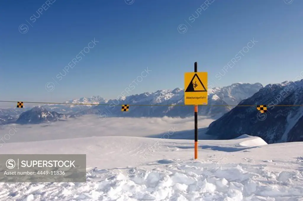 A warning sign in the snow under blue sky, Berchtesgardener Land, Bavaria, Germany