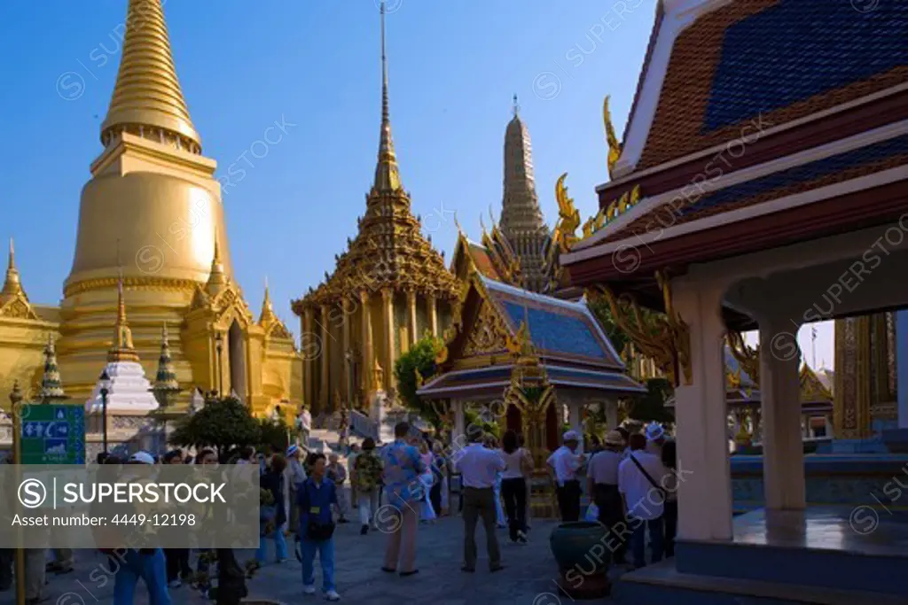 Group of tourists visiting the Wat Phra Kaew, the most important Buddhist temple of Thailand, Phra Sri Rattana Chedi and Phra Mondop, the library in background, Ko Ratanakosin, Bangkok, Thailand