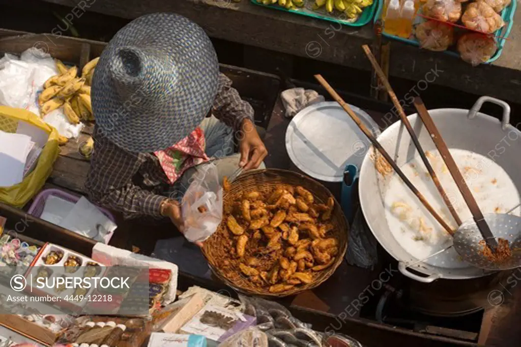 Woman offering food and souvenirs at Floating Market, Damnoen Saduak, near Bangkok, Ratchaburi, Thailand