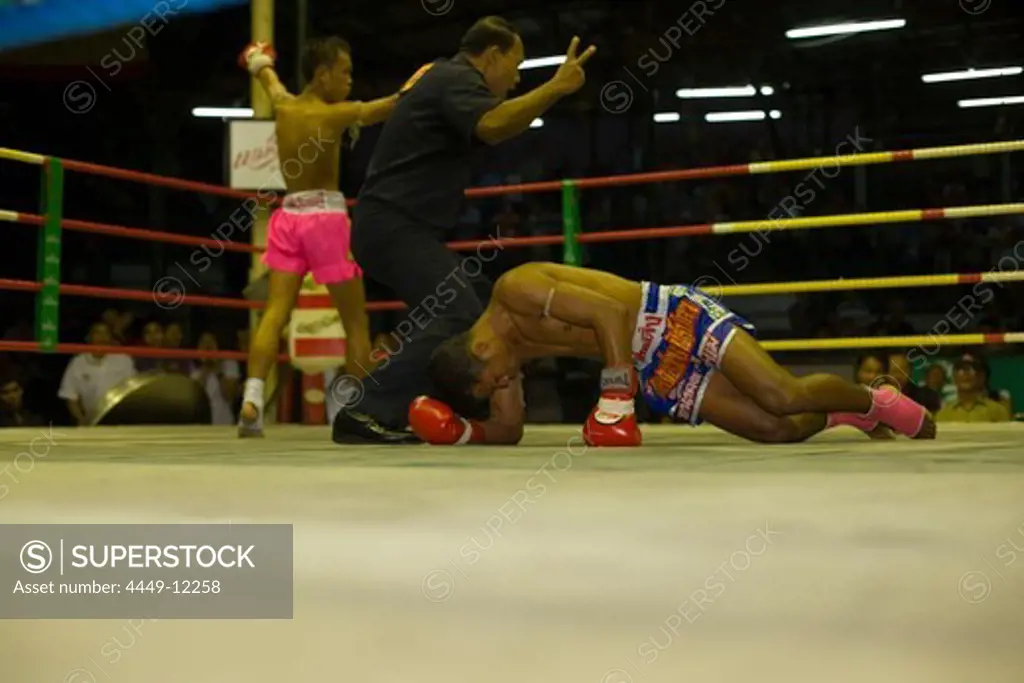 Thai boxer lying on ground, referee counting out, Thai Boxing, Lumphini Stadium, Bangkok, Thailand