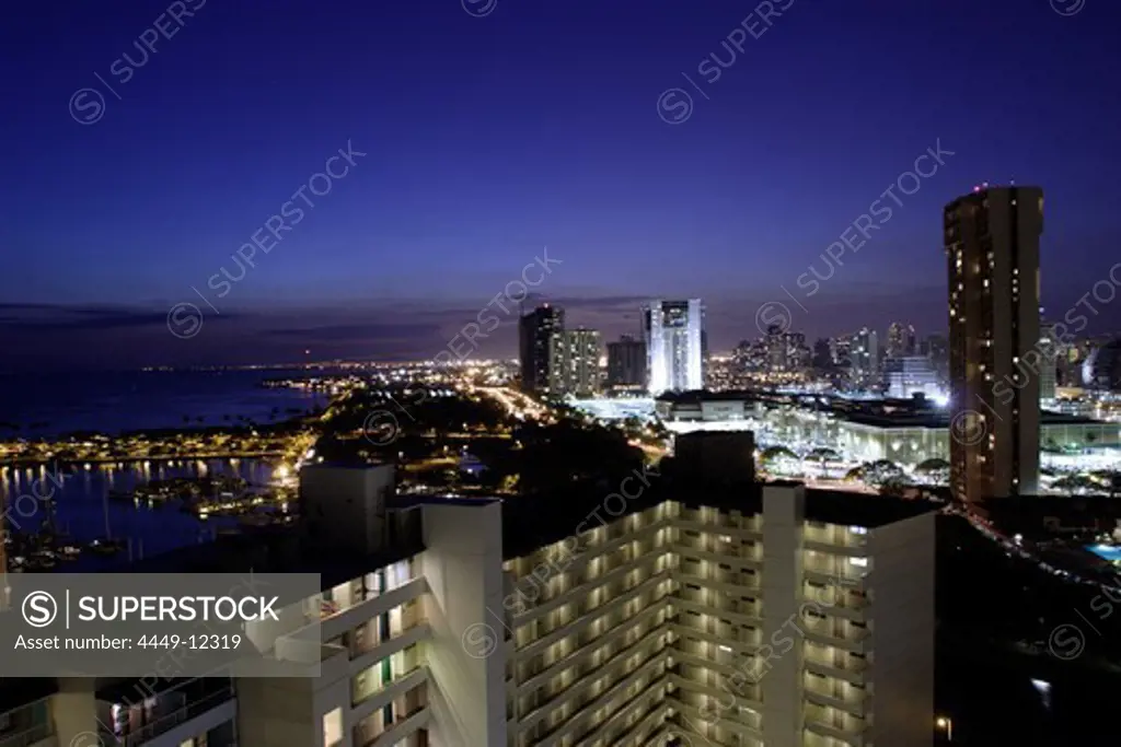 Illuminated city with high rise buildings at the coastline, Honolulu, Hawaii, America, USA