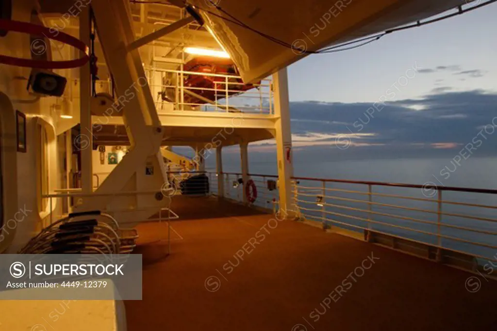 Illuminated deserted deck at sunset, cruise ship MS Delphin Renaissance