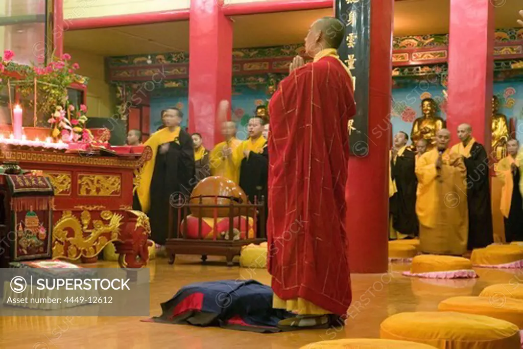 Praying monks at the main hall of the Wannian monastery, Emei Shan, Sichuan province, China, Asia