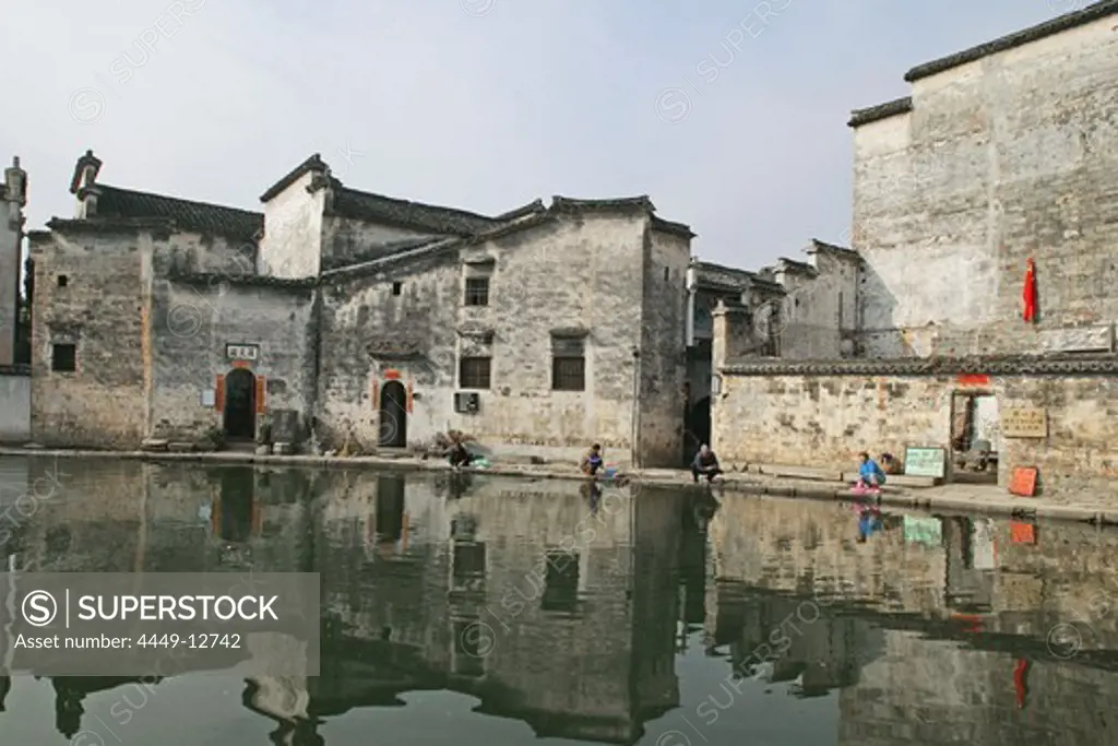 women washing in village pond, part of a complex water system, where water is channelled in front of every house, Hongcun, Huangshan, ancient village, living museum, China, Asia, World Heritage Site, UNESCO