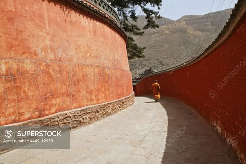 Monk walking to Pusa Ding Summit, high walls of the monastery, Xiantong Monastery, Wutai Shan, Five Terrace Mountain, Buddhist Centre, town of Taihuai, Shanxi province, China
