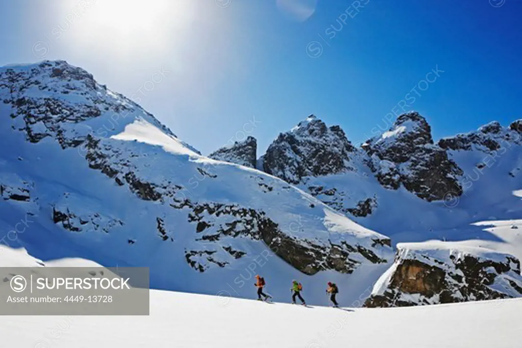 A group of skitourists climb with skis and skins to the top of the Popova Kapa in the Rila Mountains, Bulgaria