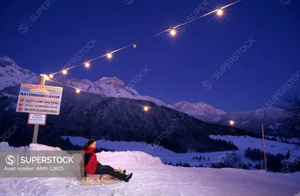 Sledging at start of illuminated toboggan-run, Kronreith, Maria Alm, Salzburg, Austria