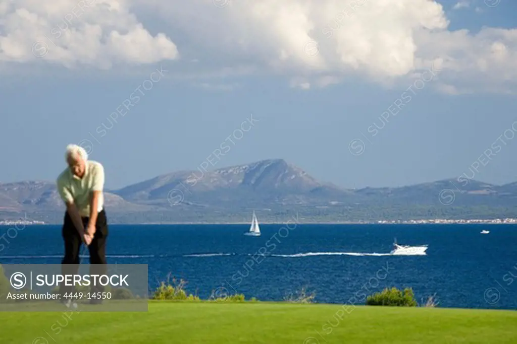Senior man playing golf, Club de Golf Alcanada, Badia de Alcudia, Majorca, Spain