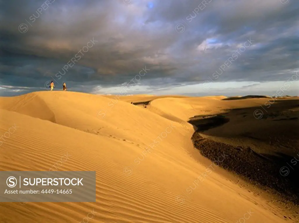 Couple walking through the dunes of Maspalomas, nature reseve, Gran Canaria, Canary Islands, Spain