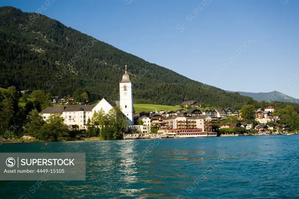 View over lake Wolfgangsee to parish and pilgrimage church and Hotel Im Weissen Roessel am Wolfgangsee, St. Wolfgang, Upper Austria, Salzkammergut, Austria