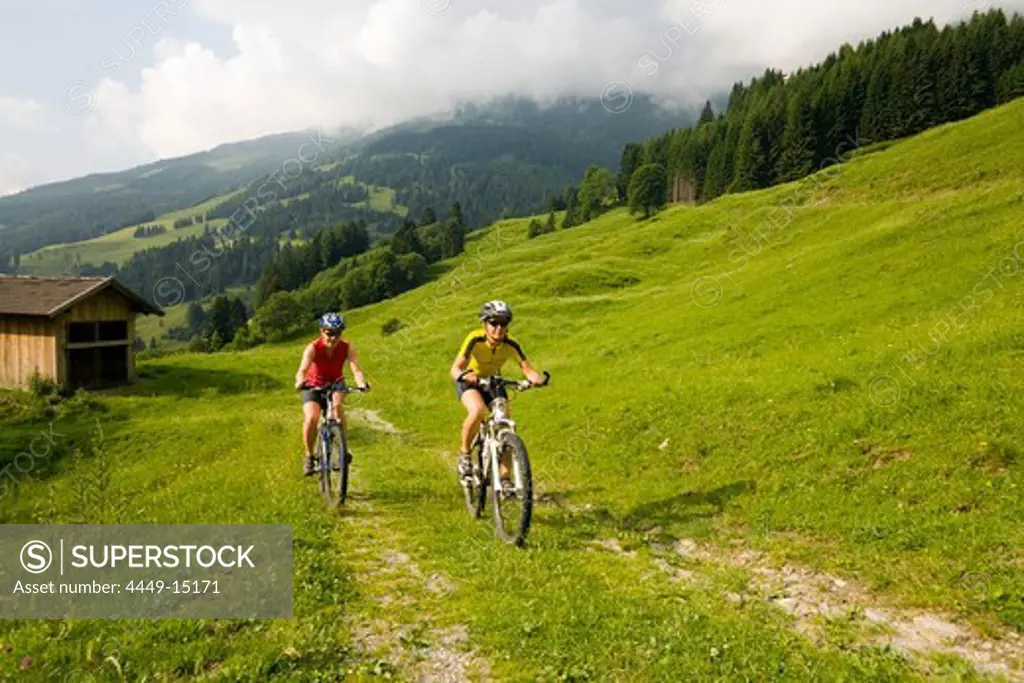 Two women riding mountain bikes, Amoseralm, Dorfgastein, Gastein Valley, Salzburg, Austria