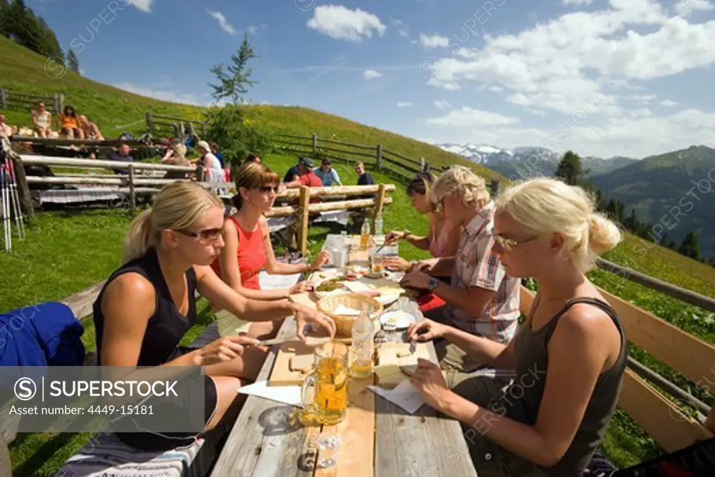 Tourists eating a Jause (snack) at Bichlalm (1731 m), Grossarl Valley, Salzburg, Austria