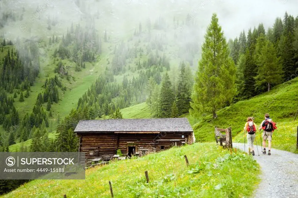 Couple arriving Karseggalm (1603 m, one of the oldest mountain hut in the valley), Grossarl Valley, Salzburg, Austria