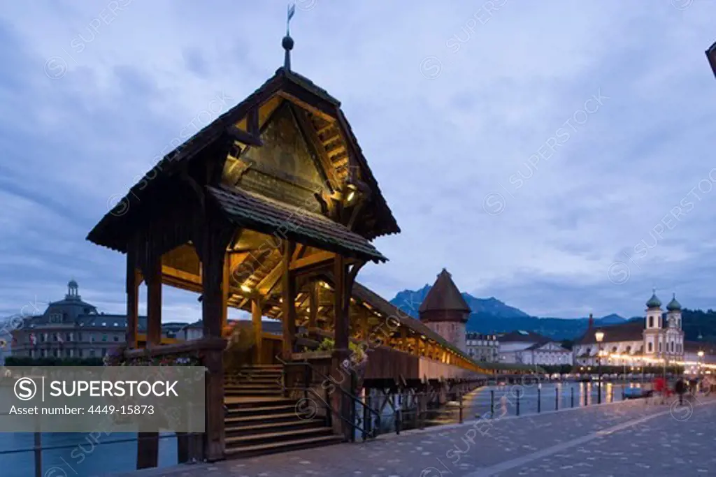 Entry of the Kapellbruecke (chapel bridge, oldest covered bridge of Europe) and Wasserturm in the evening, Jesuit Curch, first large sacral baroque building in Switzerland, in background, Lucerne, Canton Lucerne, Switzerland