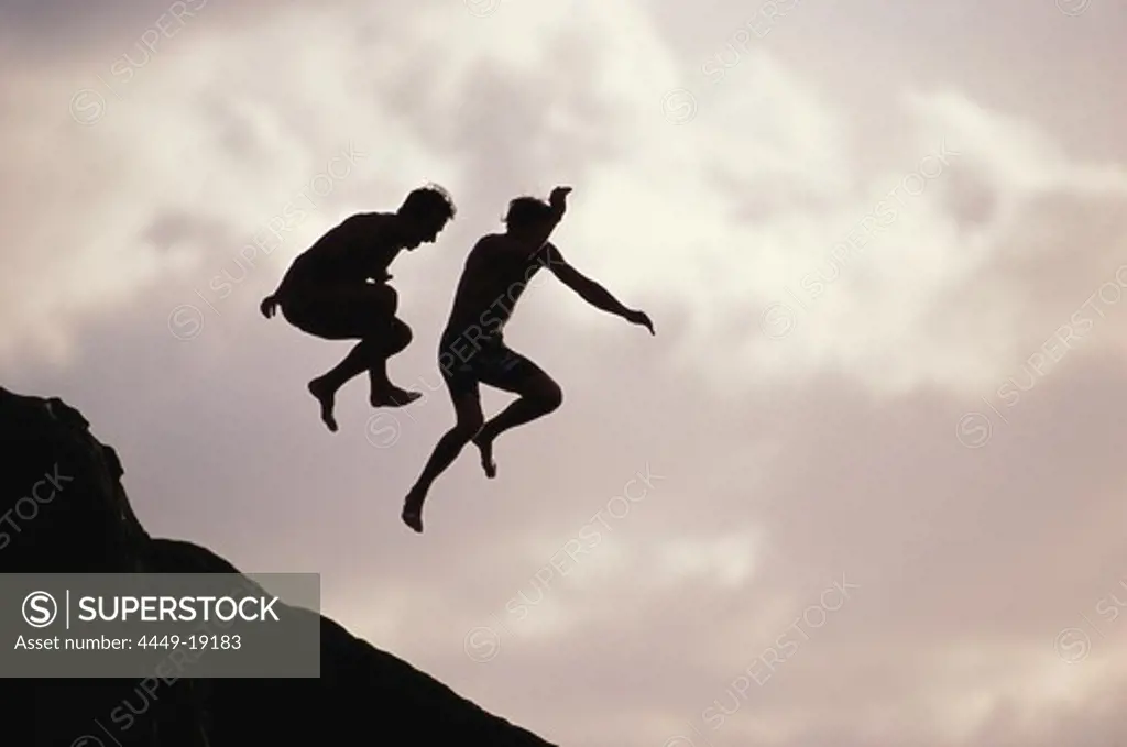 Men jumping in the water, Sunset Beach, Oahu, Hawaii, USA