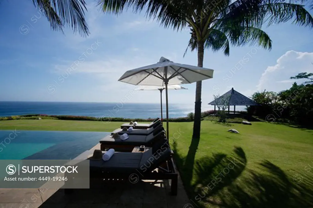 Sun loungers at the edge of the swimming pool, near Uluwatu, Bali, Indonesia