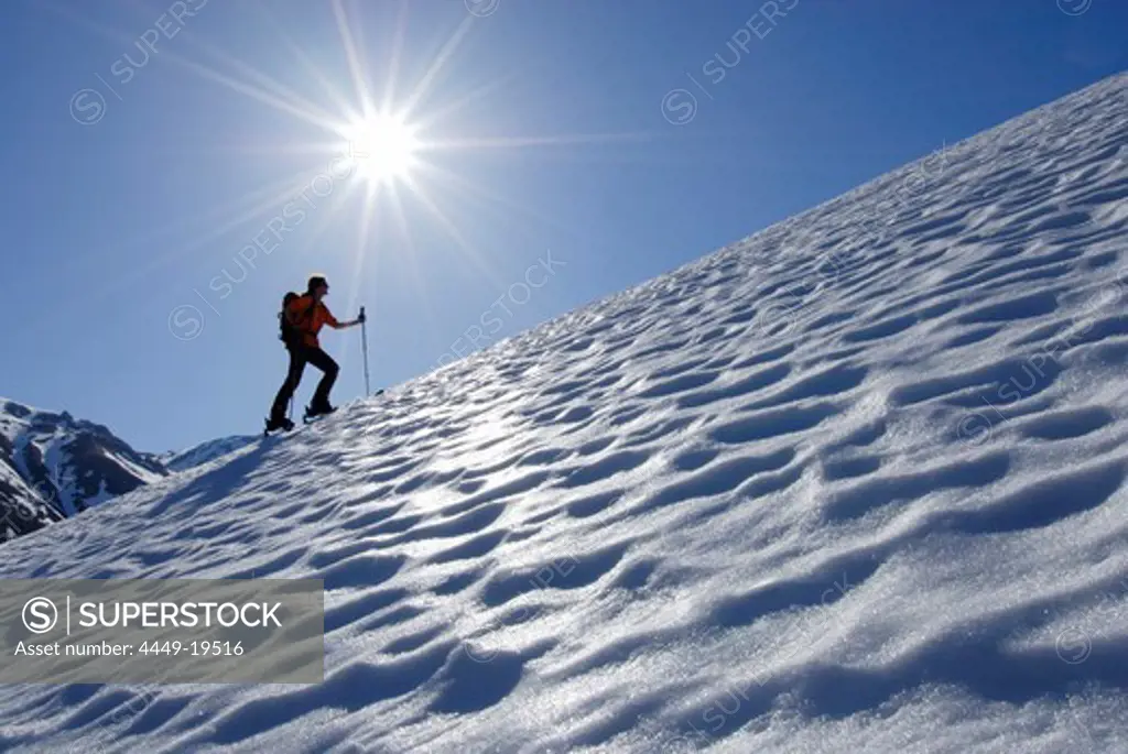 Backcountry skier ascending Leutkircher Huette, Lechtal range, Vorarlberg, Austria