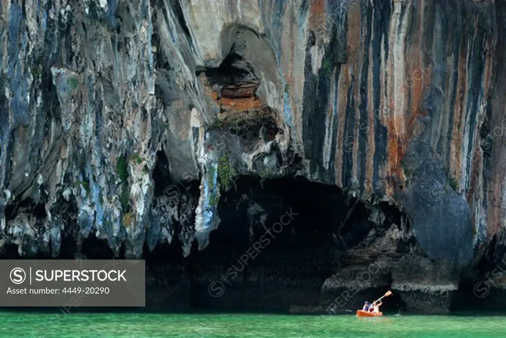 Canoe in front of limestone cliffs in the Bay of Phang Nga, Thailand