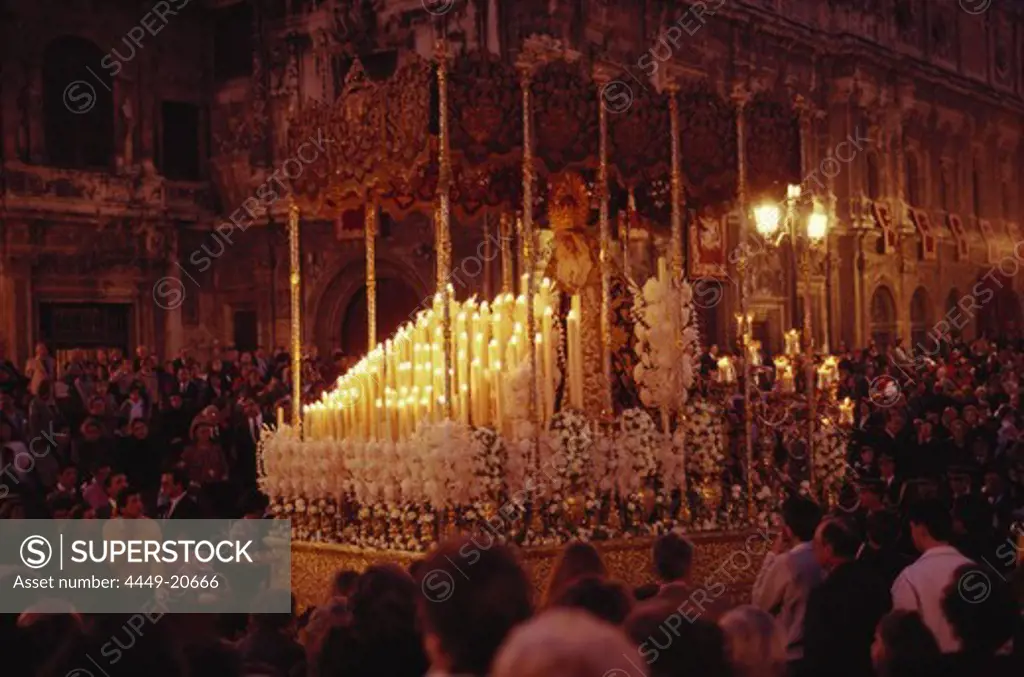 People carrying a massive, candlelit statue of Saint Mary to the cathedrale at night, Plaza San Francisco square, Seville, Andalusia. Spain