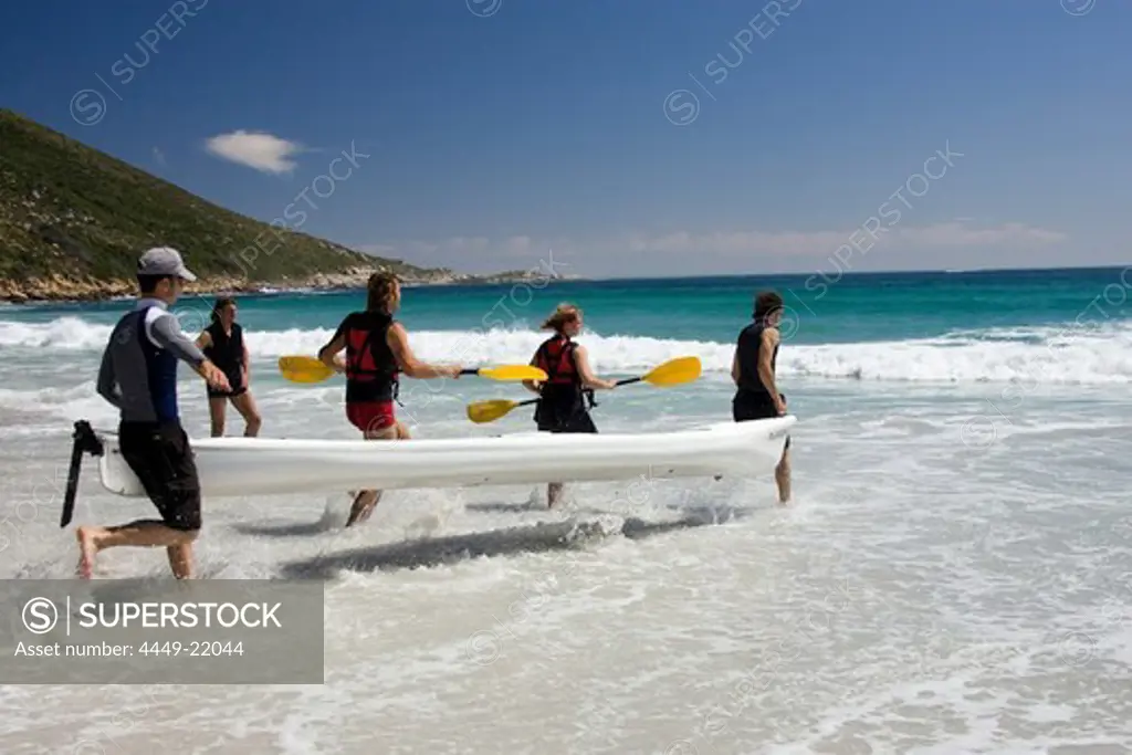 Five people carrying a boat into the water, Sandy Bay Beach, Cape Town, South Africa, Africa, mr