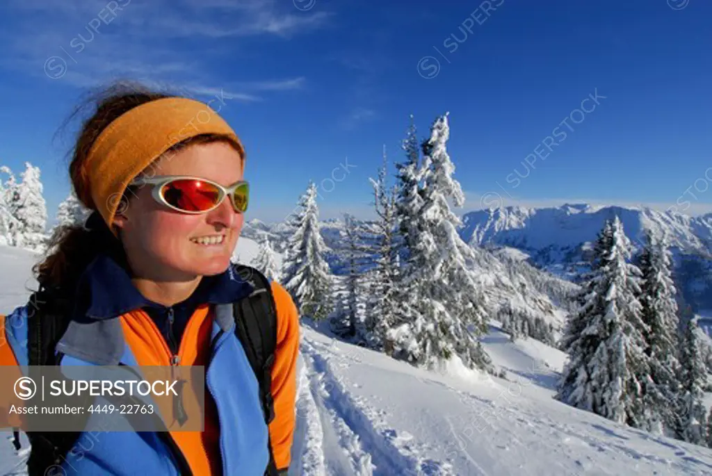 young woman ascending Spieser between deeply snow-covered fir trees, Allgaeu range, Allgaeu, Swabia, Bavaria, Germany